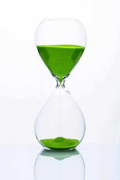 Hourglass with green sand stock photo