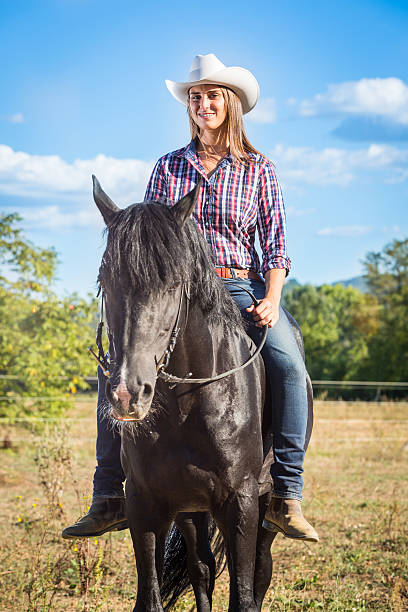 istock Cowgirl Riding a Black Stallion Horse 180920719