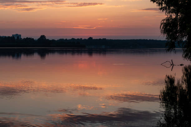 istock Sunrise on lake with clouds reflecting in water 1809215064