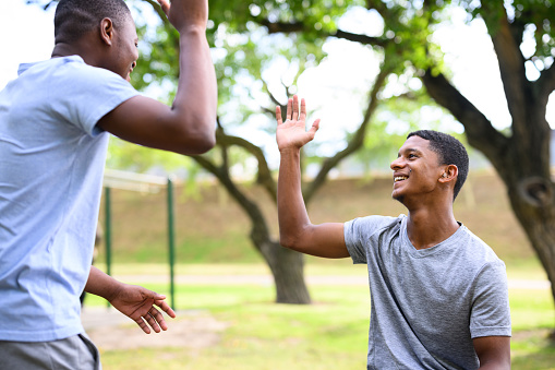 Young man wearing hearing aid exercising with friend in the park