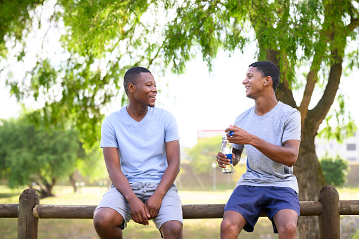 Young man wearing hearing aid exercising with friend in the park
