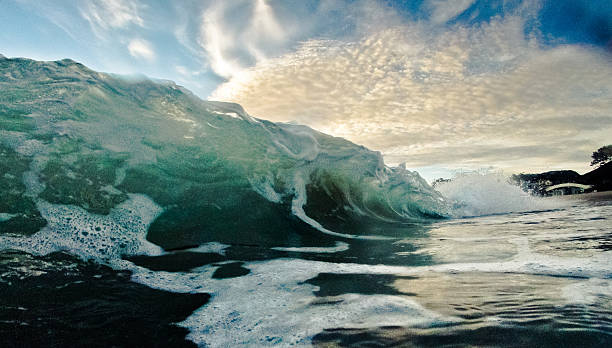 istock Wave breaking at the beach with clouds and blue sky 180924269