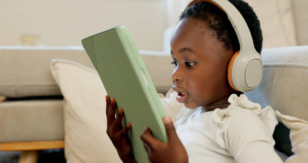 istock Black child, tablet and headphones for home education, language e learning and translation or video streaming. Kid or girl listening to audio and watch on digital technology for games and school 1809257709