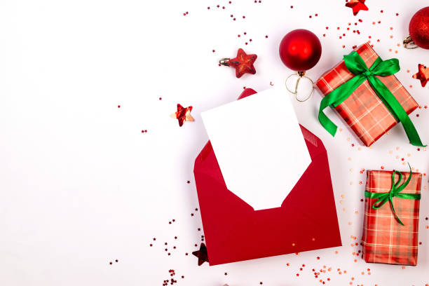 istock Christmas composition. Red gift boxes with green ribbon at white background. Red christmas baubles. Merry Christmas greeting card, 1809268075