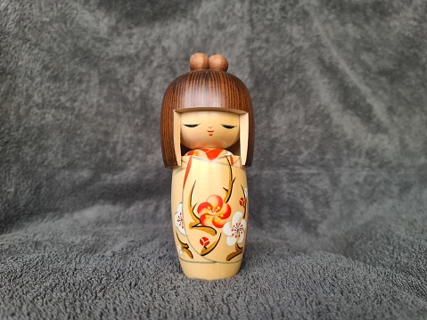 japanese kokeshi doll. Japanese figurine. Kokeshi (こけし, 小芥子) are simple wooden Japanese dolls with no arms or legs that have been crafted for more than 150 years as a toy for children.