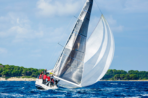 Sailing crew on sailboat in action on regatta. Models and event regatta property released.