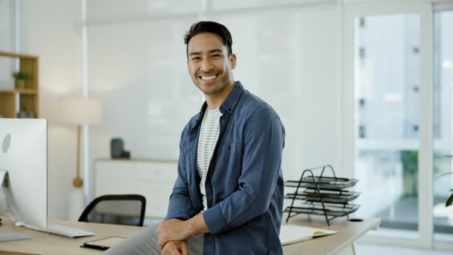 Smile, happy Asian man at desk with confidence and portrait of tech business owner, entrepreneur or professional. Modern office of creative manager, laughing and face of businessman in workplace.