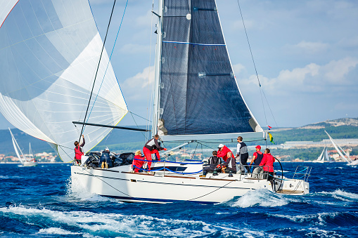 Sailing crew on sailboat in action on regatta. Models and event regatta property released.