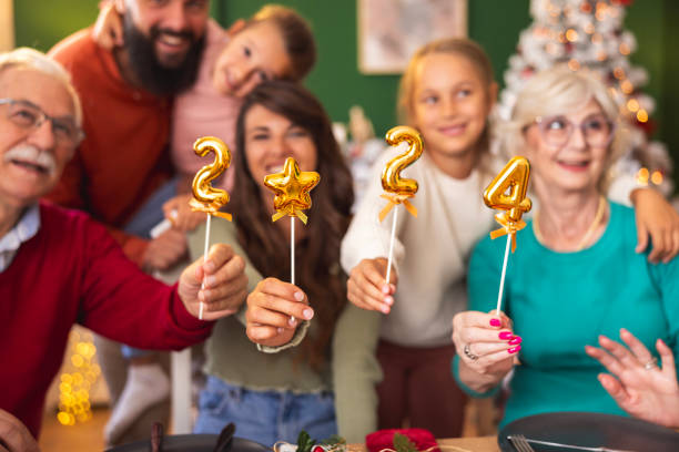 istock Family holding numbers 2024 while having Christmas dinner at home 1809332585