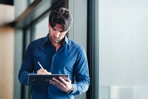 Young businessman using digital tablet outdoors on the office terrace