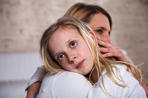 Mother and daughter embracing. Mother is consoling her girl.