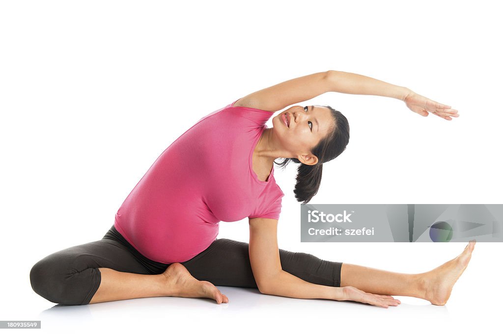 Pregnant woman yoga position seated side stretch. Prenatal yoga. Full length Asian pregnant woman doing yoga exercising stretching, fullbody isolated on white background. 30-39 Years Stock Photo