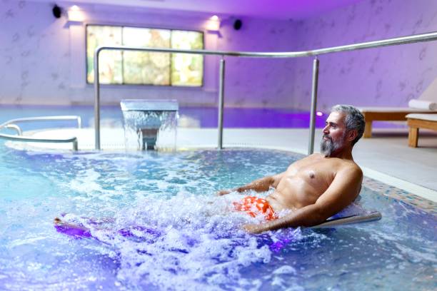 istock Man enjoying a water massage in the swimming pool 1809359086