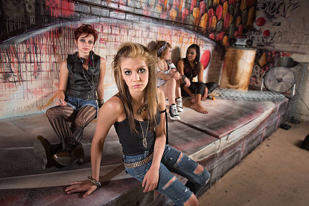 Serious group of female teenagers sitting by wall