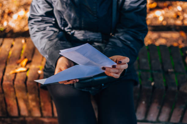 istock Close-up of an envelope with a letter in a woman's hand. 1809372085