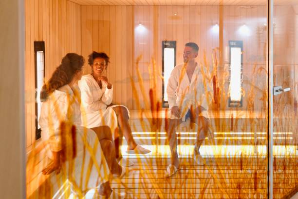 Multiracial friends relaxing in the sauna Group of multiracial friends relaxing in the sauna Sauna Therapy stock pictures, royalty-free photos & images