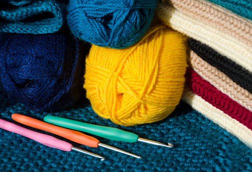 Balls of wool yarn, knitted patterns and hooks. Favorite hobby, handmade.