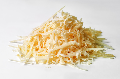 Heap of delicious grated parmesan cheese on white background