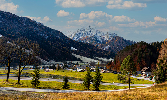 Panoramic view on the road with  mountain village environs, grassy hills. Picturesque traveling, seasonal at countryside