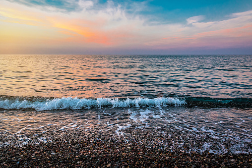 Beautiful sunset, sea and pebble cobbled beach at sunset