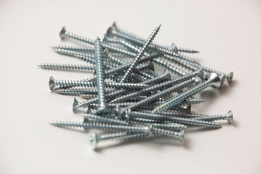 Self-tapping screws, screws, anchors, dowels, bolts, rods, rivets, nuts, hardware, metal fasteners on a white background