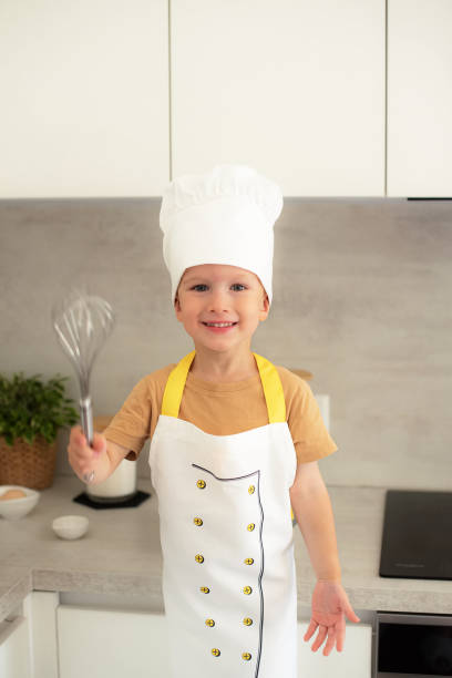 istock Little Caucasian Boy on Chef Hat Cooking in the Kitchen Home Early Education Development Apron Ingredients 1809422273