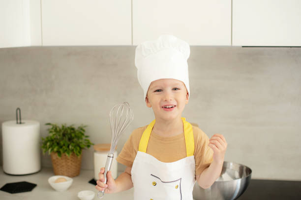 istock Little Caucasian Boy on Chef Hat Cooking in the Kitchen Home Early Education Development Apron Ingredients 1809422284