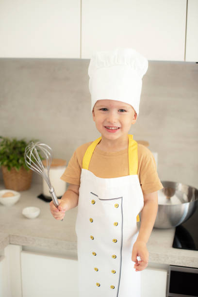 istock Little Caucasian Boy on Chef Hat Cooking in the Kitchen Home Early Education Development Apron Ingredients 1809422287