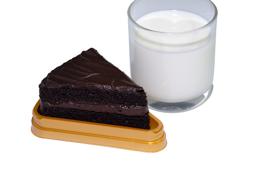 Glasses filled with white milk and chocolate cakes are arranged together on an easily distinguishable white background.