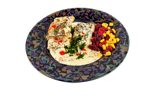 ready-to-eat fish dish with cream sauce and vegetables, isolated in a dark bowl