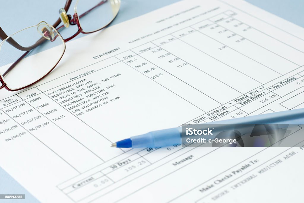 Close up of a medical bill featuring glasses and a pen  doctor bill on blue background Financial Bill Stock Photo