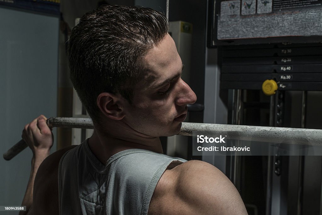 Hombre joven en una máquina de remo - Foto de stock de Adulto libre de derechos