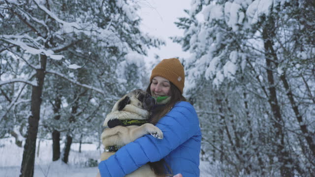 Happy Woman with Her Dog Contemplating Frozen Winter in the Forest