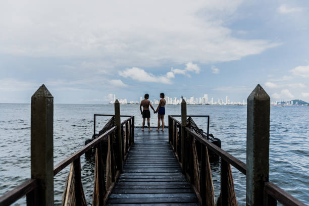 Couple holding hands on the beach pier
