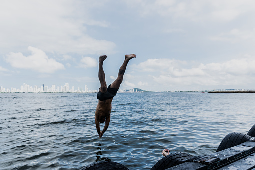 Man diving into the sea from the beach pier