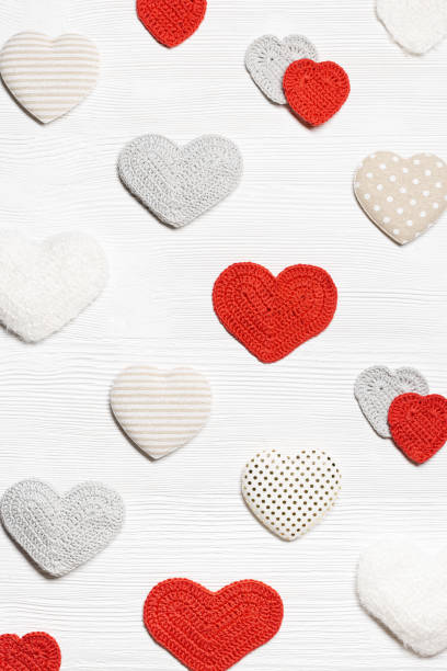 istock Valentines day geometric pattern from different knit hearts valentine, handmade colored crochet heart on white wood table, handmade gift for romance holiday, symbol of love. Top view 1809473940