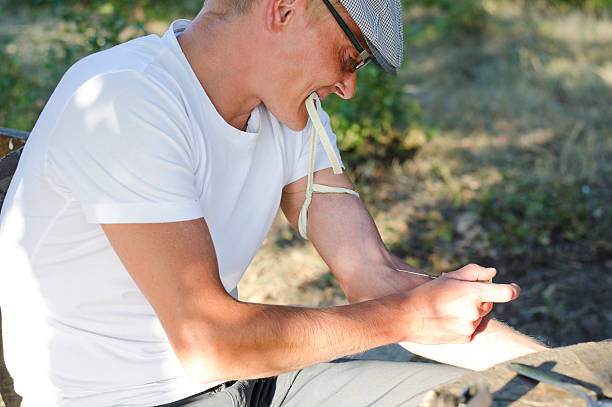 istock Addicted man injecting his tied arm intravenously 180948165