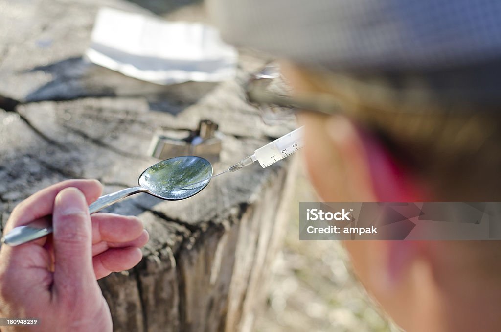 Addicted hombre preparando una dosis con soluble heroína - Foto de stock de Adicción libre de derechos