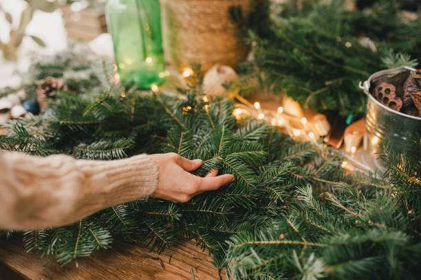 istock Woman making natural Christmas wreath using pine branches and festive holiday decorations. 1809493651