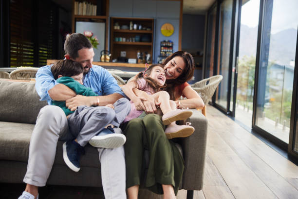 istock Parents and their little children laughing while playing on their sofa 1809496231
