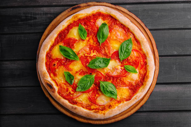 istock Pizza Margherita on black wood background 1809501301