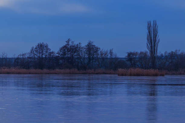 Autumn evening landscape. A pond with ice on it.