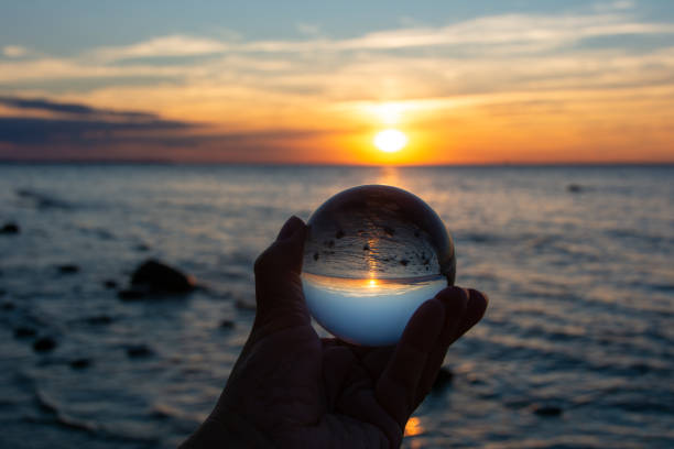 istock Beach and sea reflected in a ball in a human hand 1809503495