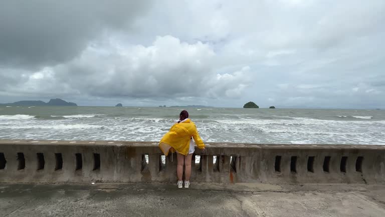 Young woman standing on the beach during a storm