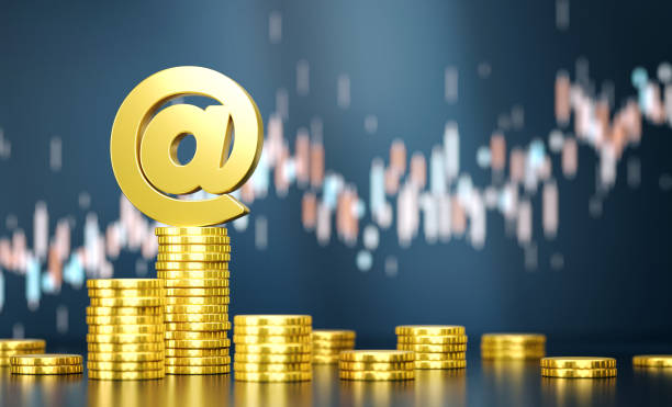istock At Symbol On Top Of Coin Stacks Before Blue Financial Graph 1809516887