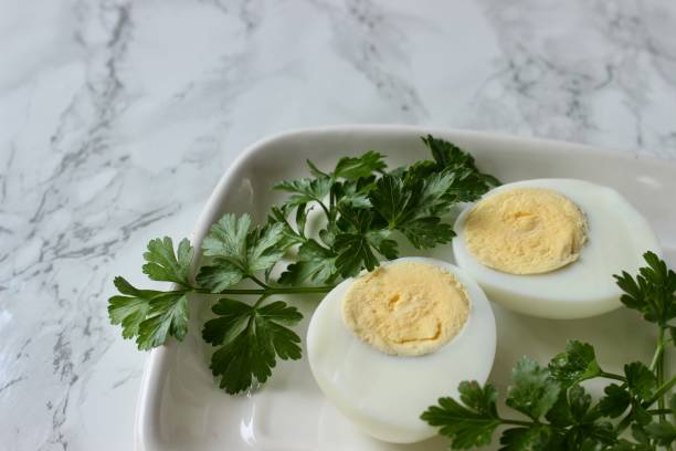 istock Boiled chicken egg and parsley on a white plate on a marble background 1809523810
