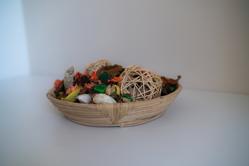 Close-up of aromatic potpourri of dried flowers in bowl on white wooden table indoors