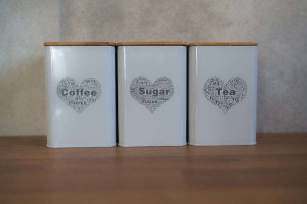 Cans of sugar, coffee and tea on the kitchen surface