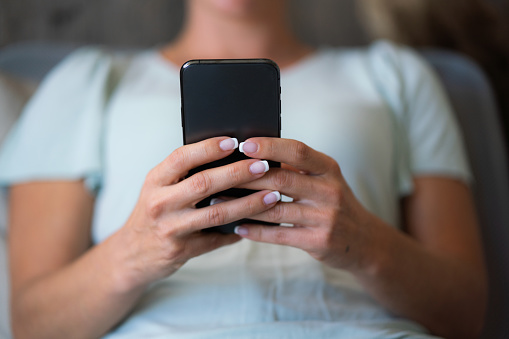 Close-up of mobile phone in unrecognizable females hands