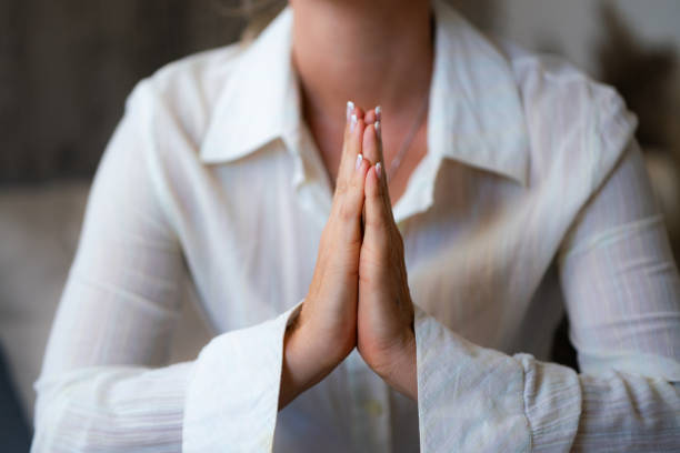 istock Unrecognizable woman praying at home 1809531875